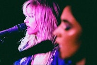 two women singing into a microphone
